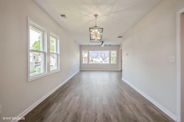 interior space with dark hardwood / wood-style floors, a healthy amount of sunlight, and a chandelier