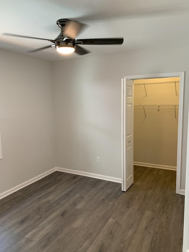 unfurnished bedroom with dark hardwood / wood-style floors, ceiling fan, and a closet