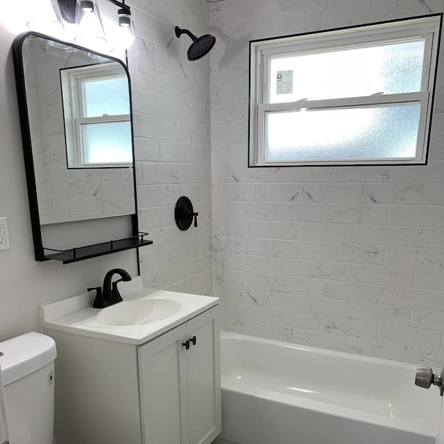 full bathroom featuring vanity, tiled shower / bath combo, and toilet