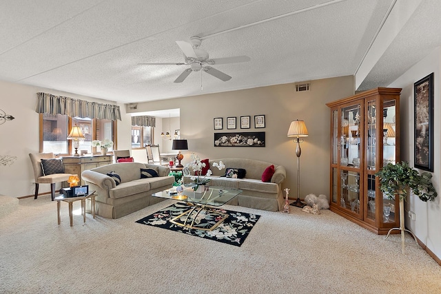 living room with ceiling fan, a textured ceiling, and carpet