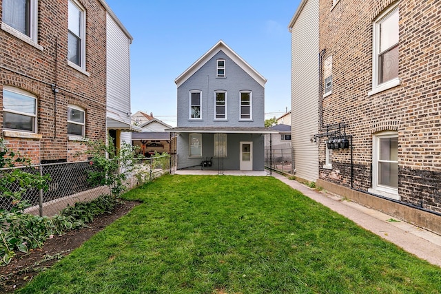 rear view of property featuring a yard and a patio area