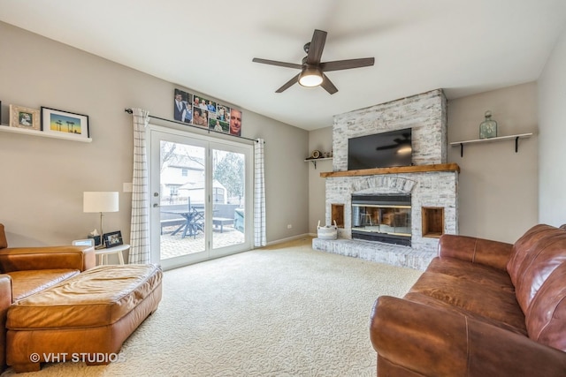 carpeted living room with a ceiling fan, a large fireplace, and baseboards