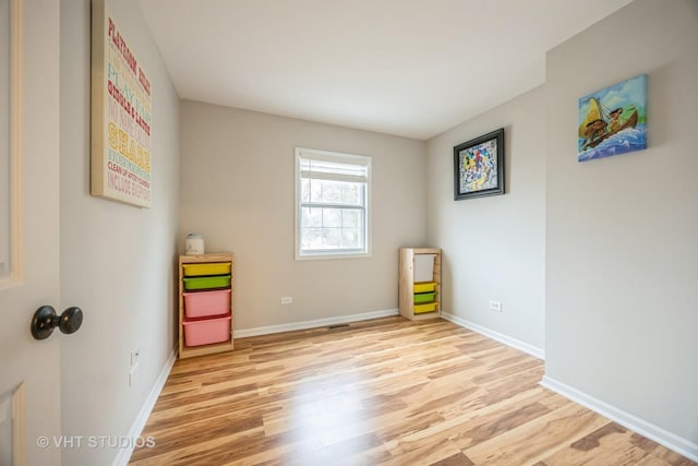 recreation room with light wood-style flooring and baseboards