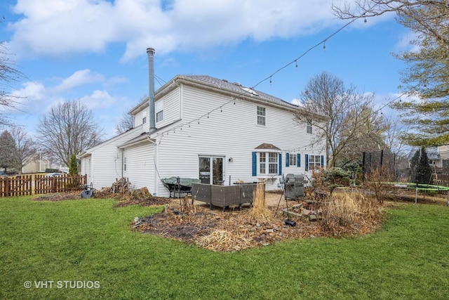 back of property featuring a lawn and fence