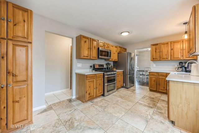 kitchen with stainless steel appliances, brown cabinetry, light countertops, and a sink