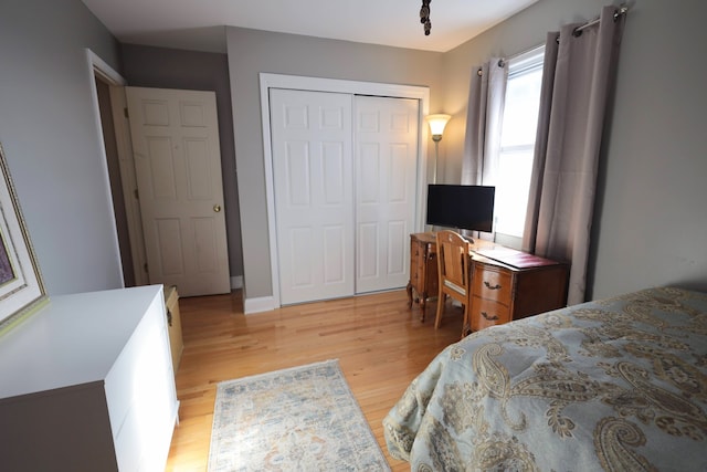 bedroom with light hardwood / wood-style flooring and a closet