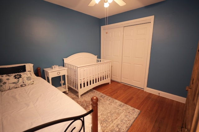 bedroom featuring dark wood-type flooring, a closet, and ceiling fan