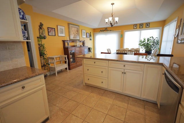 kitchen with pendant lighting, stainless steel dishwasher, a healthy amount of sunlight, and a tray ceiling