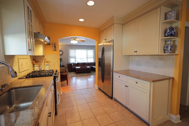 kitchen featuring range hood, sink, light tile patterned floors, stainless steel appliances, and light stone countertops