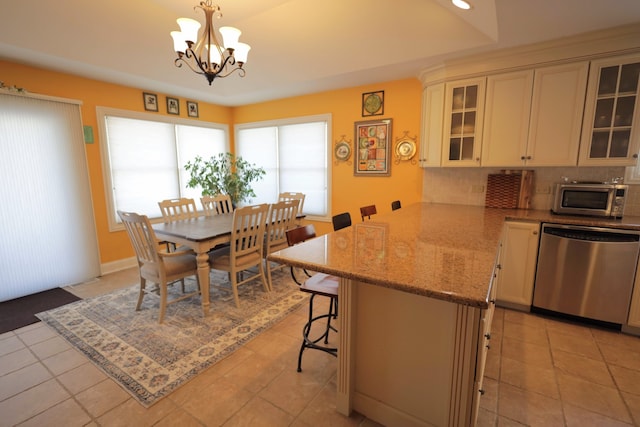 tiled dining area featuring a chandelier