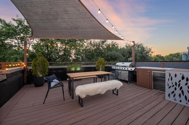 deck at dusk with area for grilling, grilling area, and beverage cooler