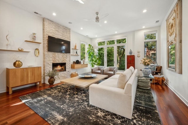 living room featuring a fireplace, dark wood-type flooring, and ceiling fan