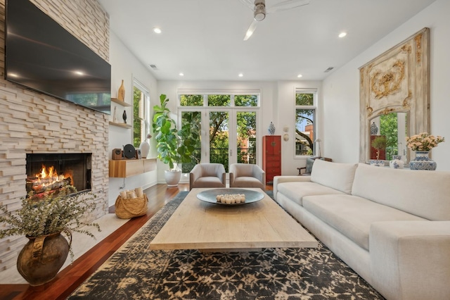 living room with ceiling fan, hardwood / wood-style floors, and a fireplace