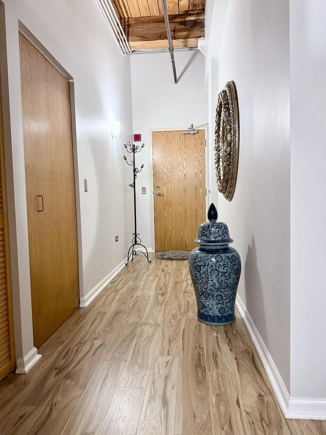 hall with wood ceiling and light hardwood / wood-style floors