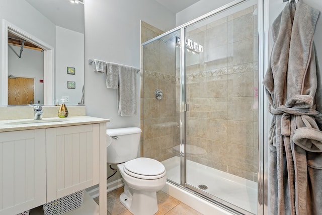 bathroom featuring vanity, toilet, tile patterned flooring, and a shower with door