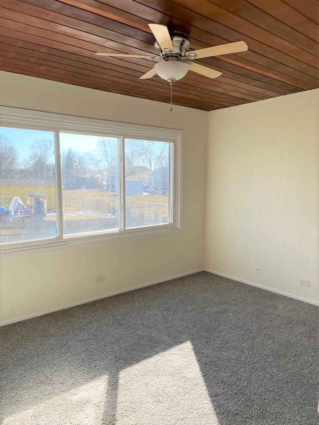 carpeted empty room with ceiling fan and wooden ceiling