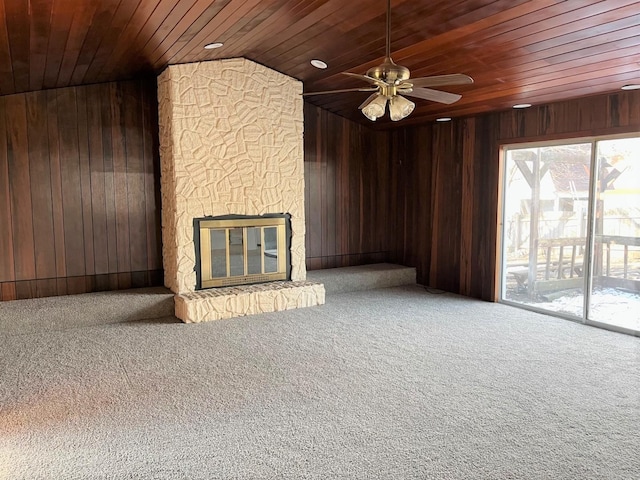 unfurnished living room featuring carpet floors, wooden ceiling, and wooden walls