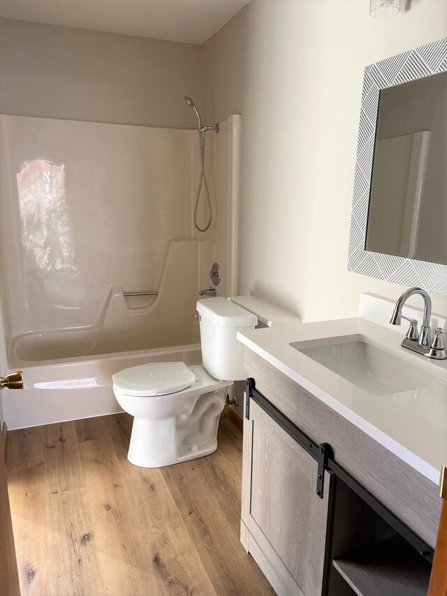 full bathroom featuring vanity, wood-type flooring, toilet, and shower / bath combination