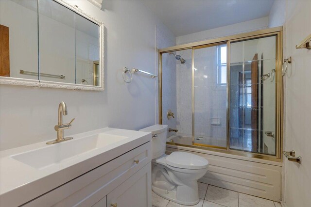 full bathroom with tile patterned flooring, vanity, enclosed tub / shower combo, and toilet