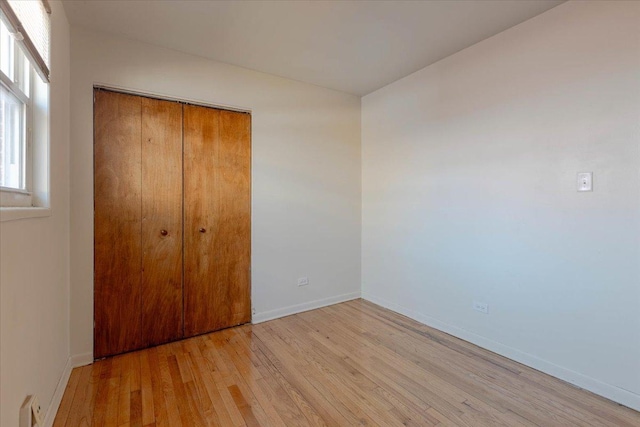 unfurnished bedroom with a closet and light hardwood / wood-style flooring