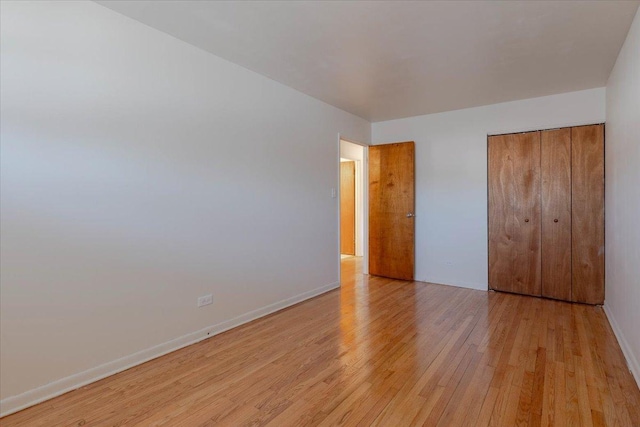 unfurnished bedroom featuring a closet and light wood-type flooring