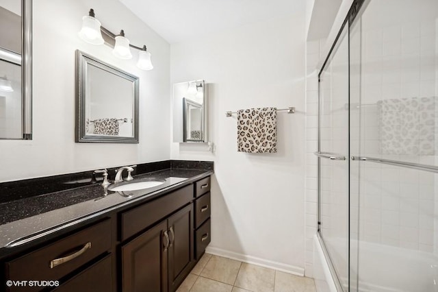 bathroom featuring tile patterned flooring, vanity, and enclosed tub / shower combo