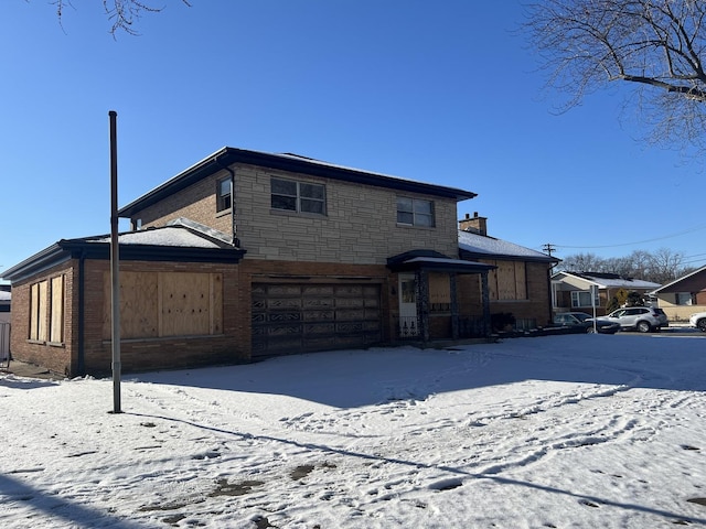 snow covered property with a garage