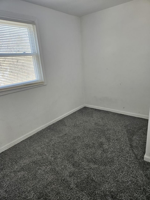 carpeted spare room featuring baseboards