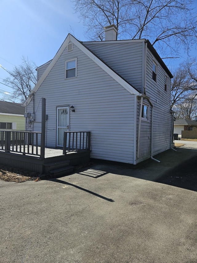 exterior space featuring a chimney and a wooden deck