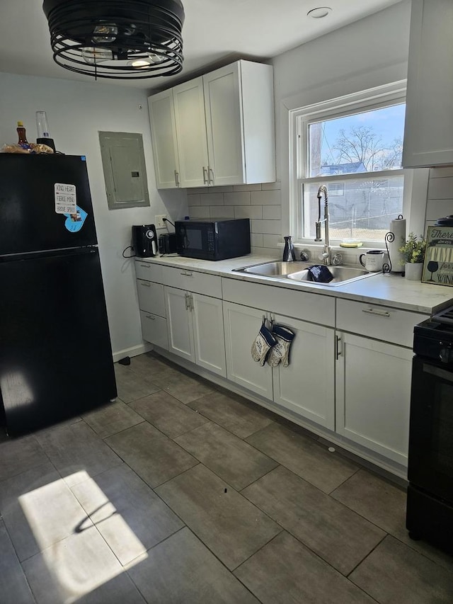 kitchen featuring a sink, light countertops, electric panel, black appliances, and tasteful backsplash