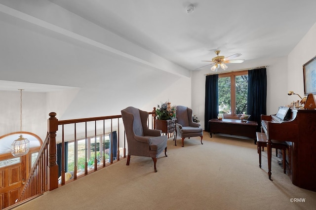 sitting room featuring ceiling fan with notable chandelier and carpet floors