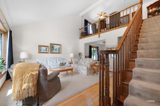 living room with hardwood / wood-style flooring, beam ceiling, and high vaulted ceiling