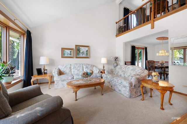 living room featuring lofted ceiling, plenty of natural light, a notable chandelier, and carpet