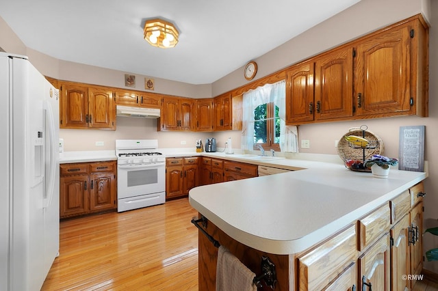 kitchen featuring white appliances, light hardwood / wood-style floors, sink, and kitchen peninsula