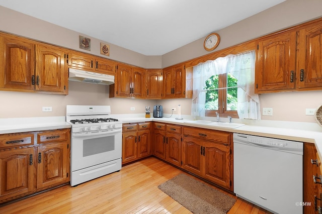 kitchen with white appliances, sink, and light wood-type flooring