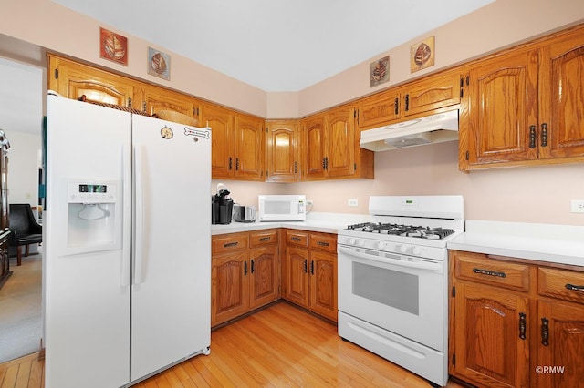 kitchen featuring white appliances and light hardwood / wood-style floors