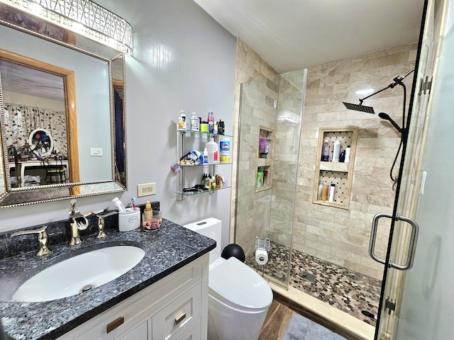 bathroom with hardwood / wood-style flooring, vanity, toilet, and an enclosed shower