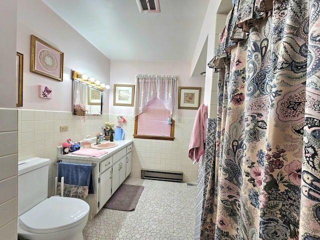 bathroom featuring toilet, tile walls, vanity, a shower with shower curtain, and a baseboard heating unit