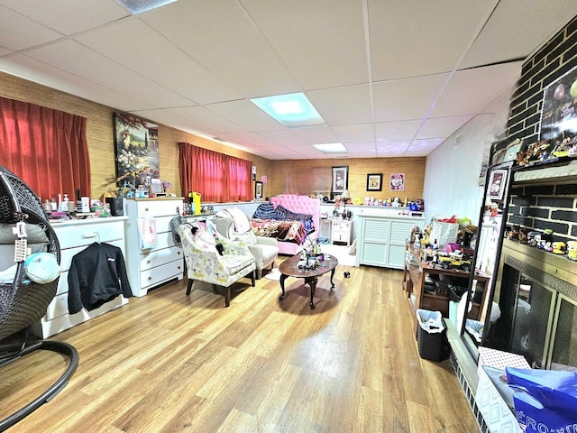 living room featuring light hardwood / wood-style floors and a drop ceiling