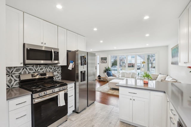 kitchen featuring tasteful backsplash, appliances with stainless steel finishes, and white cabinets