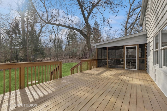 wooden deck with a lawn and a sunroom