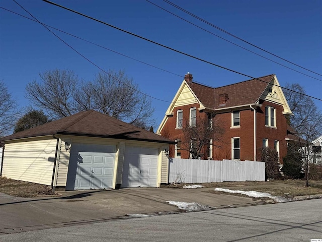 view of side of home featuring a garage and an outdoor structure