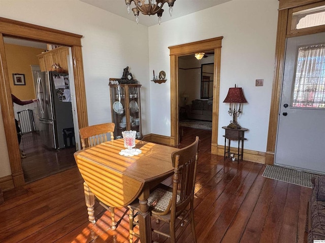 dining area featuring dark hardwood / wood-style floors and an inviting chandelier