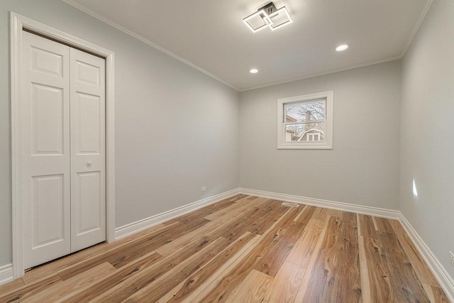 empty room featuring light hardwood / wood-style flooring and ornamental molding