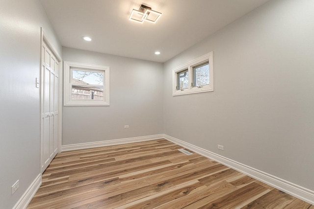 unfurnished room featuring a healthy amount of sunlight and hardwood / wood-style floors