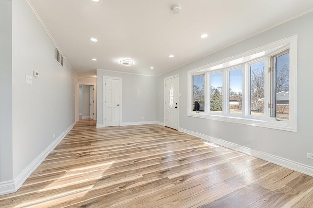 empty room with light hardwood / wood-style flooring and ornamental molding