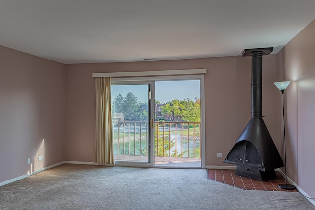 unfurnished living room with a wood stove and dark carpet