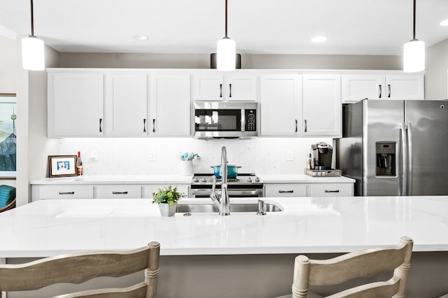 kitchen featuring pendant lighting, stainless steel appliances, and a kitchen island with sink