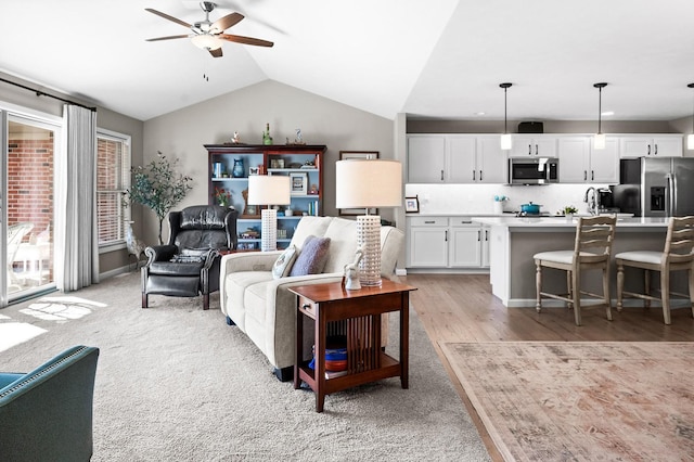 living room with vaulted ceiling, sink, and ceiling fan