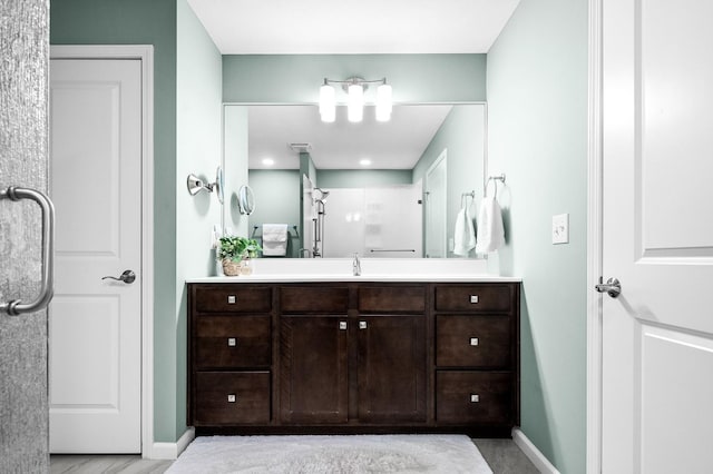 bathroom with vanity and a shower with door